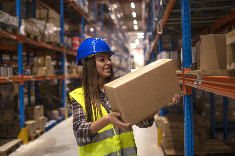 warehouse-worker-placing-cardboard-boxes-shelf-big-warehouse-storage-area