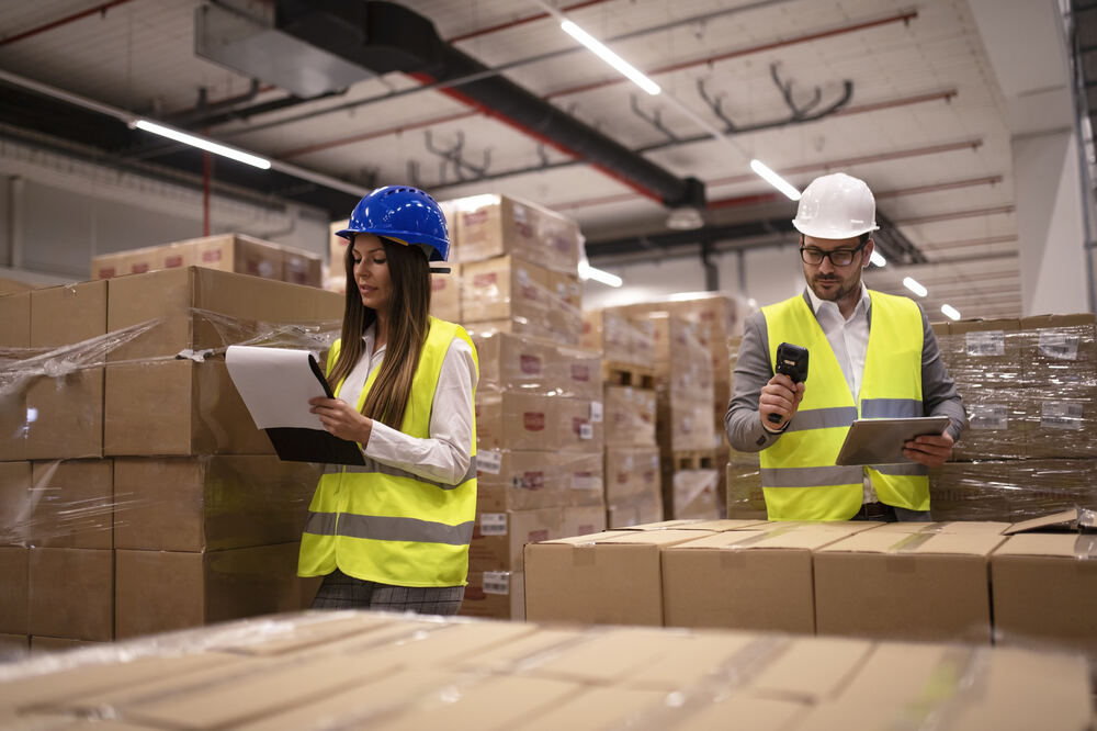 2-warehouse-worker-placing-cardboard-boxes-shelf-big-warehouse-storage-area 