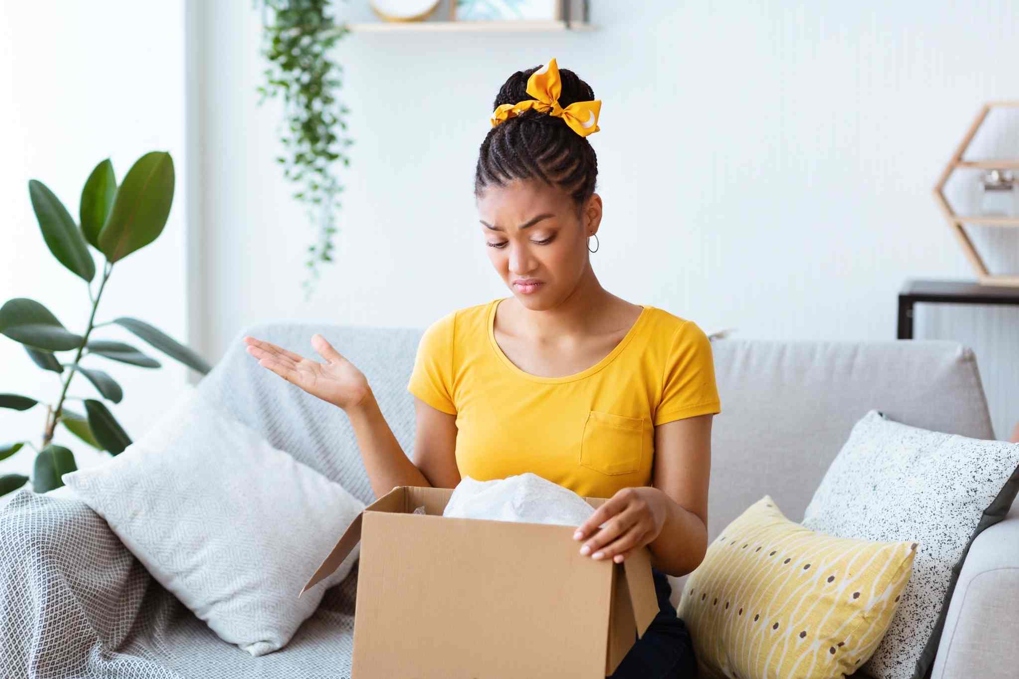 girl in yellow shirt confused on empty box