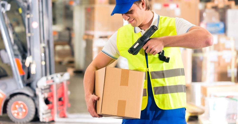 A warehouse worker scanning a box with a barcode scanner.