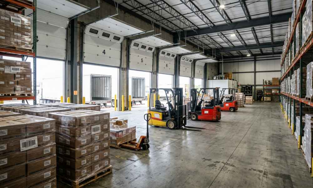 A warehouse loading dock area with several open garage bay doors