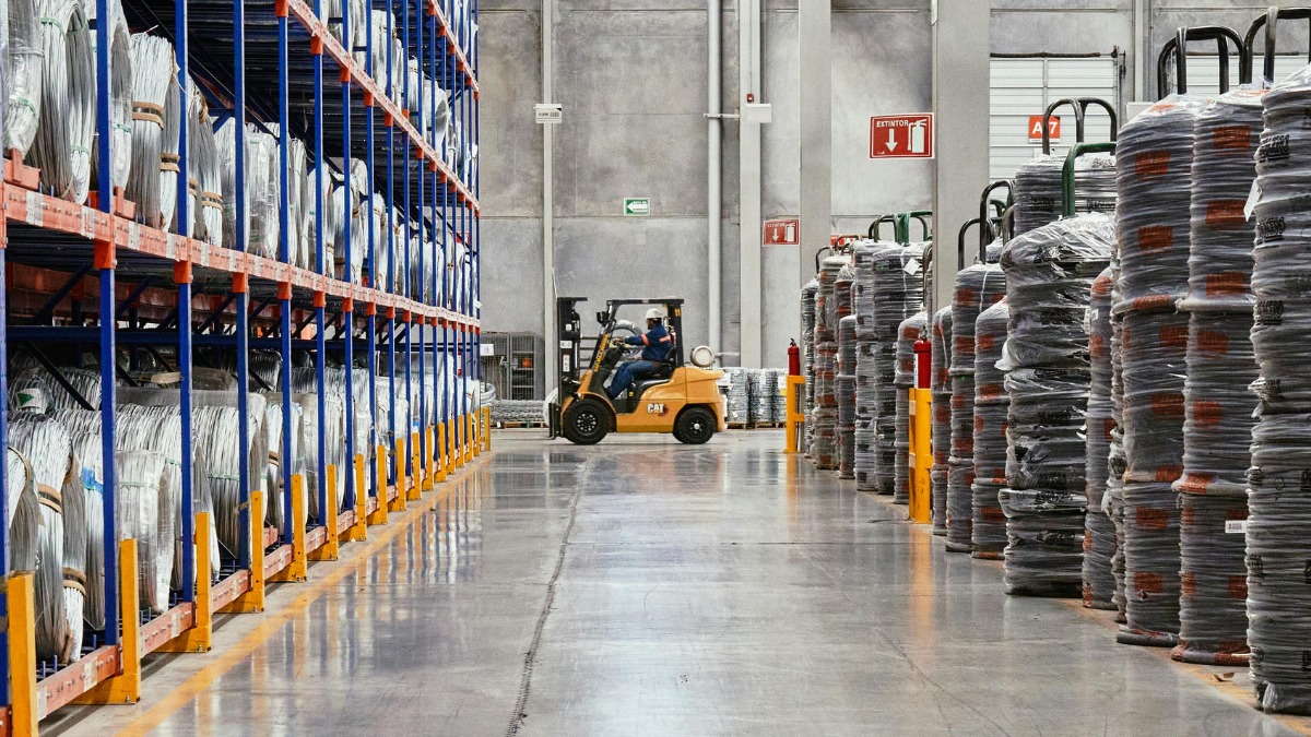 forklift operating in a wide warehouse aisle 