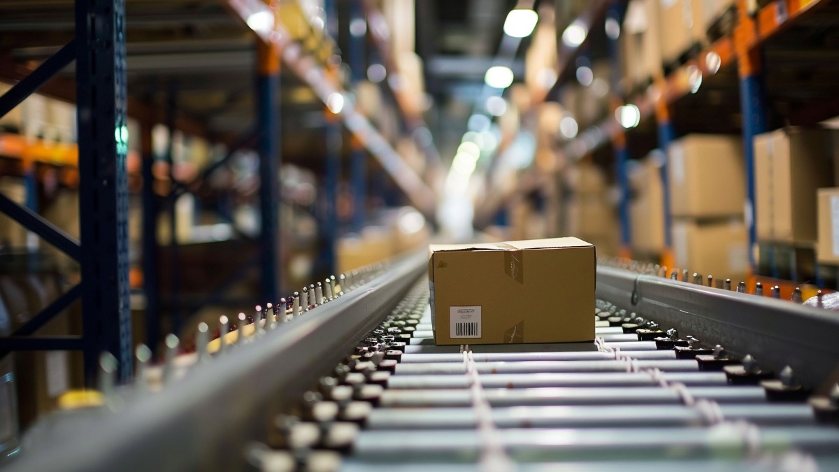 A cardboard package moving along a roller conveyor belt