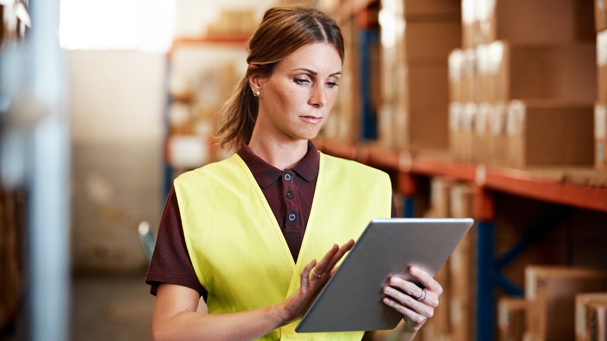 A female warehouse worker checking inventory details
